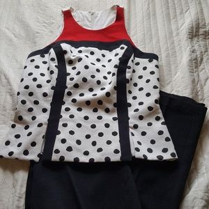 Red, black, and white polka dot top with slacks.
